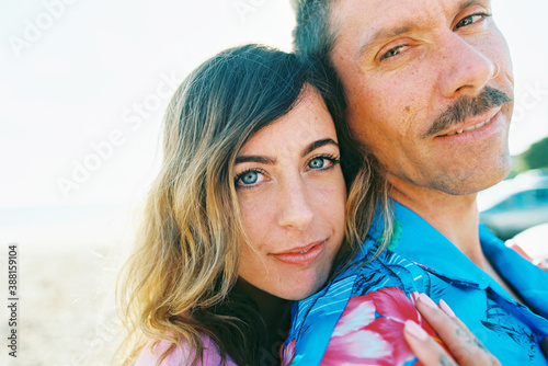 Hip couple on beach with daisies and vw van in California photo