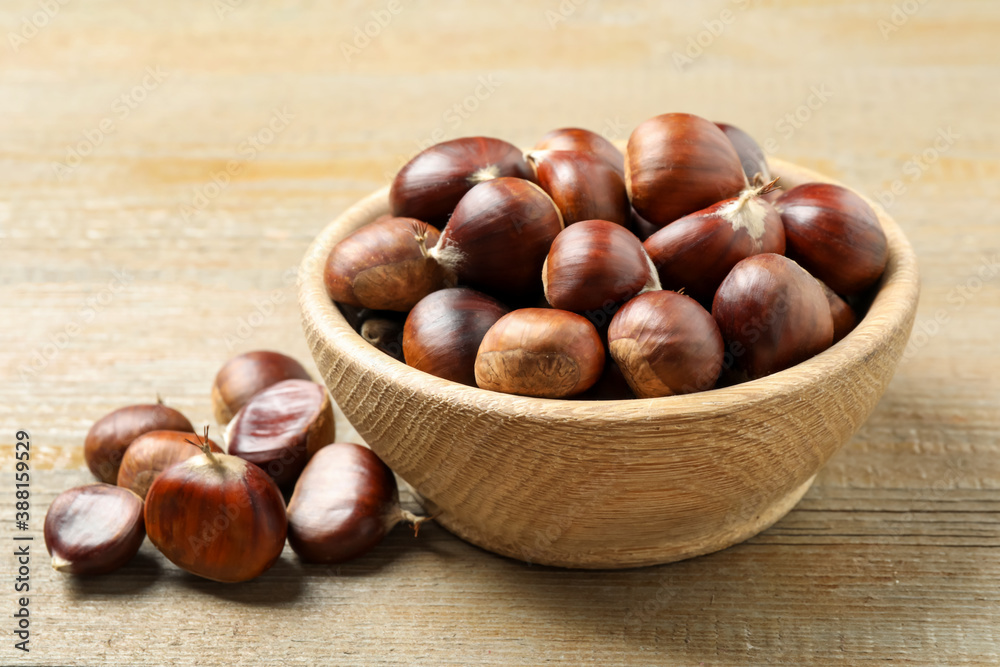 Fresh sweet edible chestnuts on wooden table Fresh sweet edible chestnuts on wooden table