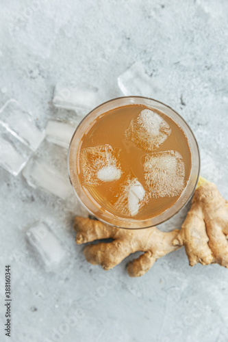 Ginger drink in glass with ginger and ice cubes