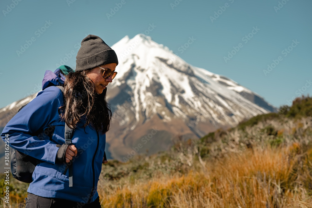 Young woman walking in the mountain with snowy peak behind. Travel concept