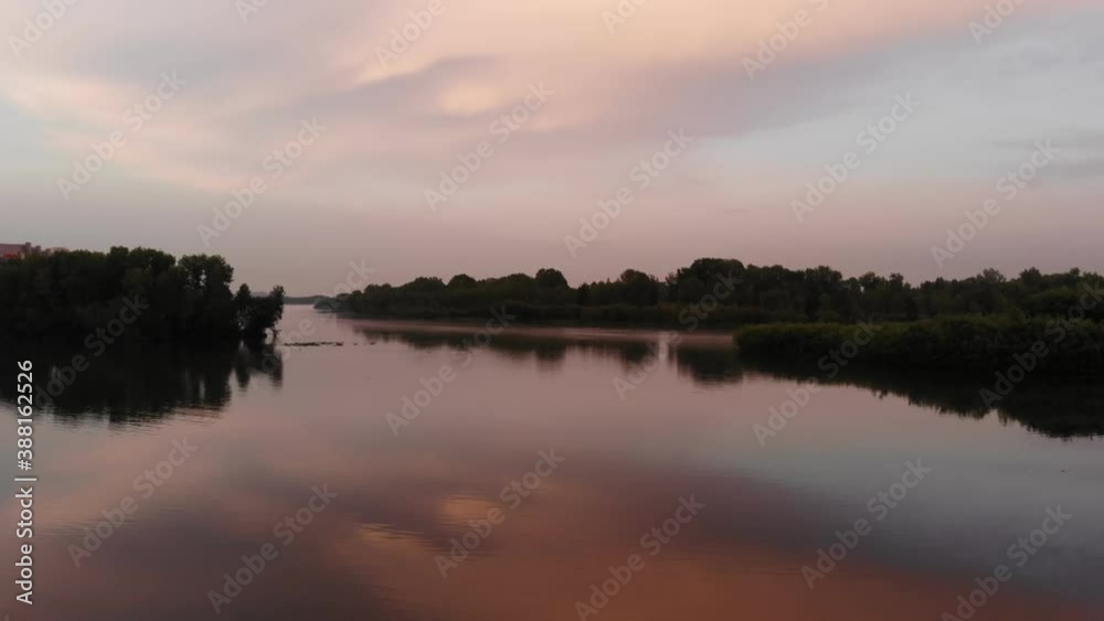 Purple sunset on the river. A very long shot. Aerial view of a drone flying Purple sunset on the river. A very long shot. Aerial view of a drone flying