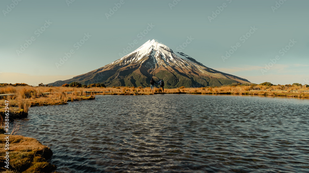Couple holding hands with the amazing view of Mount Taranaki, New Zealand