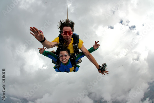Skydiving tandem having fun on a cloudy day