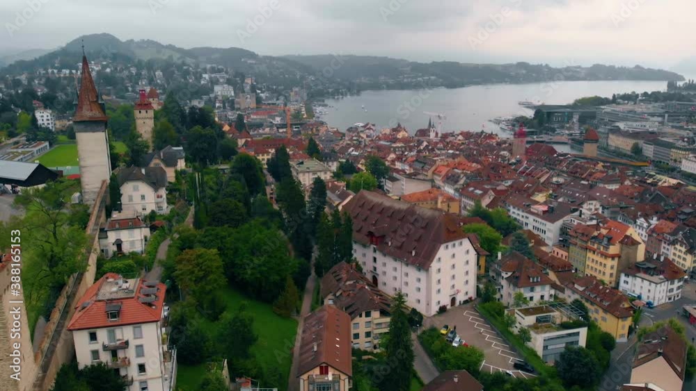 Aerial view overlooking the cityscape of Lucerne, towers and the Musegg Wall, cloudy, summer day, in Switzerland - tracking, drone shot Aerial view overlooking the cityscape of Lucerne, towers and the Musegg Wall, cloudy, summer day, in Switzerland - tracking, drone shot