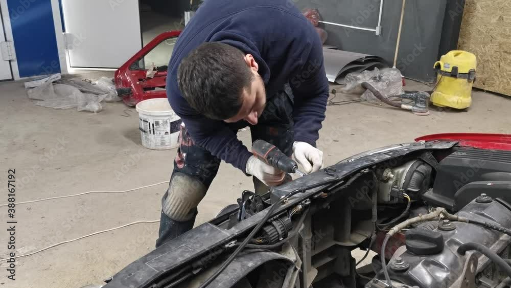 Mechanic working and screwing on the motor of a car. Mechanic working and screwing on the motor of a car.