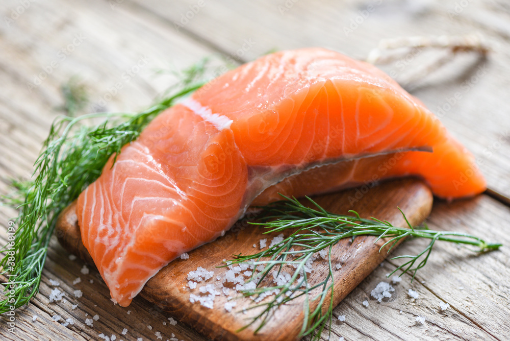 Raw salmon filet with herbs and spices on wooden background Raw salmon filet with herbs and spices on wooden background