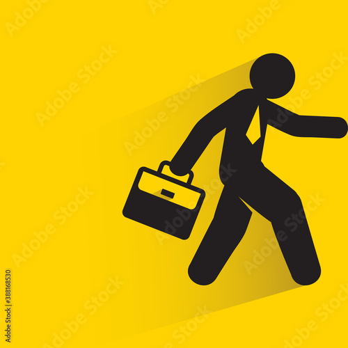 businessman holding briefcase and walking on yellow background