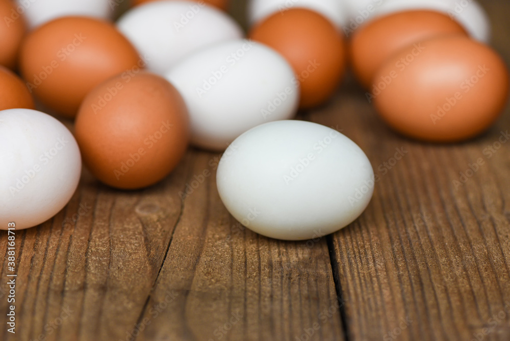 Fresh Chicken eggs and duck eggs on wooden background - white and brown egg Fresh Chicken eggs and duck eggs on wooden background - white and brown egg