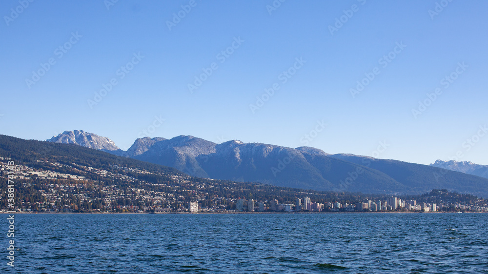 A view of North Vancouver's snow-capped mountains in the late fall, as the leaves start to change color. Taken from a sailboat in Burrard Inlet.