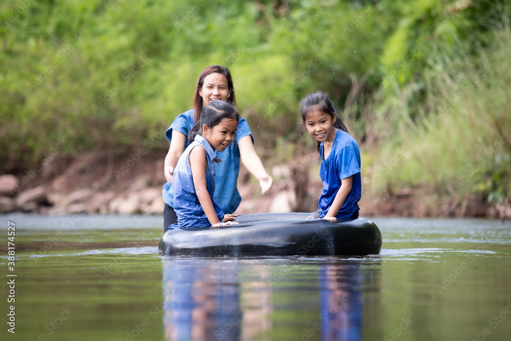 Asian mother and her daughters playing in the river together with fun and enjoy with nature. Asian mother and her daughters playing in the river together with fun and enjoy with nature.