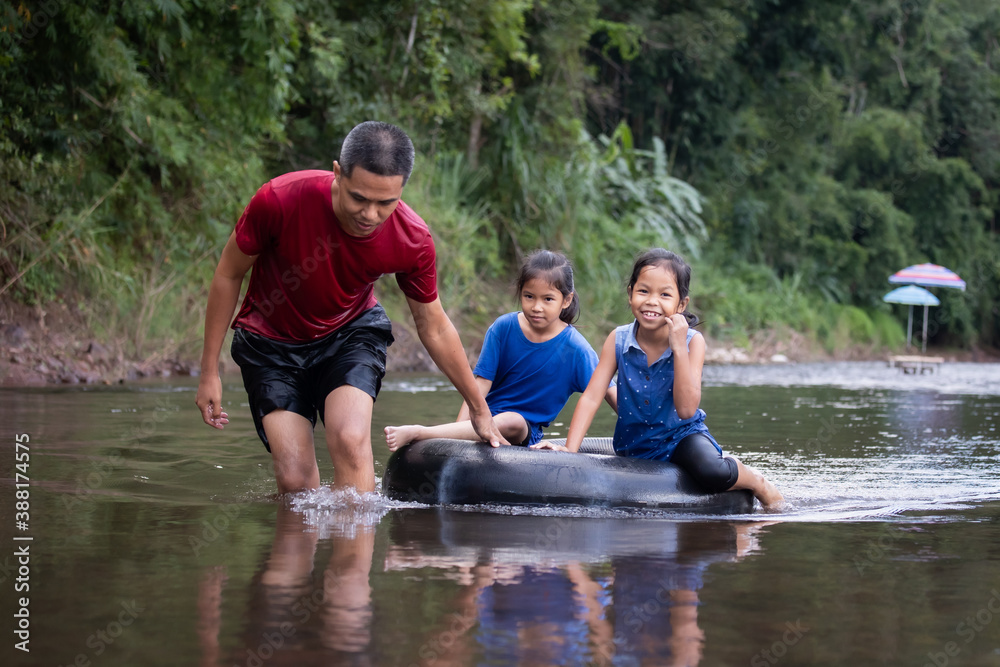 Asian father and his daughters playing in the river together with fun and enjoy with nature. Asian father and his daughters playing in the river together with fun and enjoy with nature.