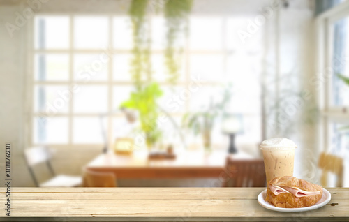 mock up Croissant ham and Ice cappuccino on wood table .Background blur indoor cafe and restaurant 