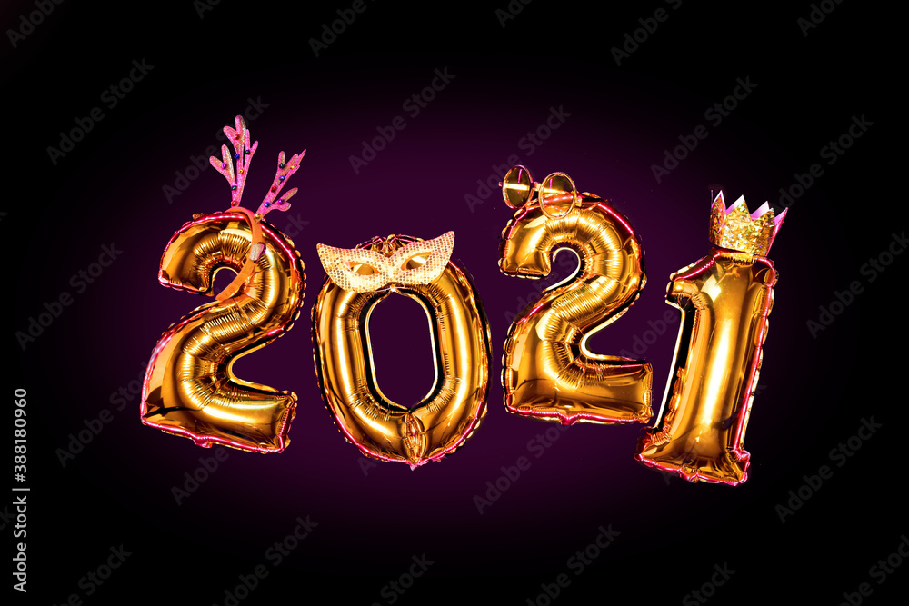 Gold glittering numbers 2021 on black background in carnival accessories, new year party concept Gold glittering numbers 2021 on black background in carnival accessories, new year party concept