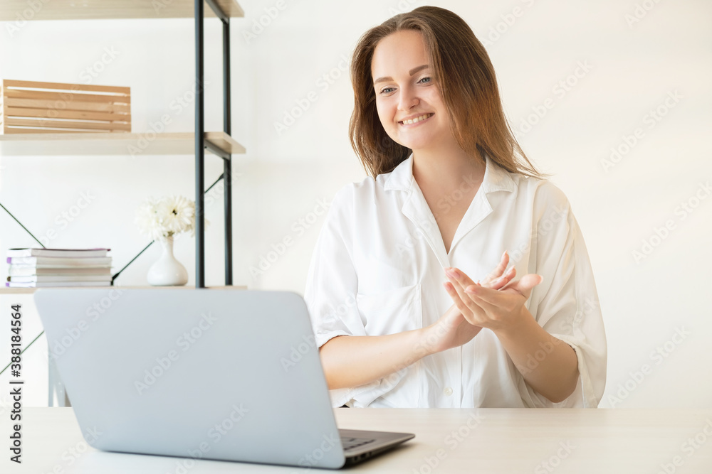 Online presentation. Successful project. Zoom chat. Online corporate meeting. Cheerful satisfied business woman supporting applauding smiling on laptop camera in light home office. Online presentation. Successful project. Zoom chat. Online corporate meeting. Cheerful satisfied business woman supporting applauding smiling on laptop camera in light home office.