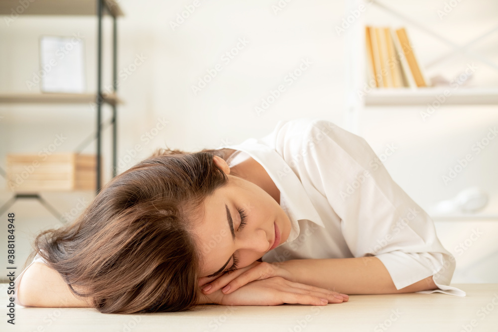 Tired woman. Hard exams. Online conference. Webinar training. Young woman falling asleep on desk light home workplace interior background. Tired woman. Hard exams. Online conference. Webinar training. Young woman falling asleep on desk light home workplace interior background.