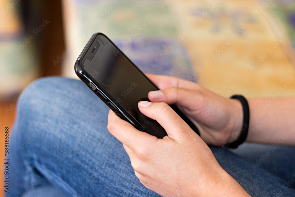 Hands of a young woman using her smart phone