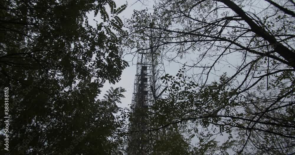 Looking Up The Trees With Duga Array In The Background At The Duga Radar Station In Chernobyl Exclusion Zone In Pripyat, Ukraine. Soviet over-the-horizon radar (OTH) system- low angle shot Looking Up The Trees With Duga Array In The Background At The Duga Radar Station In Chernobyl Exclusion Zone In Pripyat, Ukraine. Soviet over-the-horizon radar (OTH) system- low angle shot