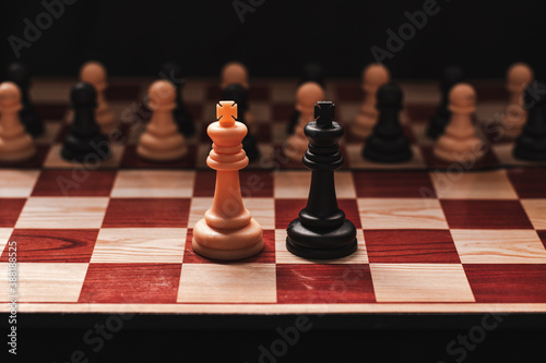 Combining army of white and black on chessboard on black background. Unification of two States concept