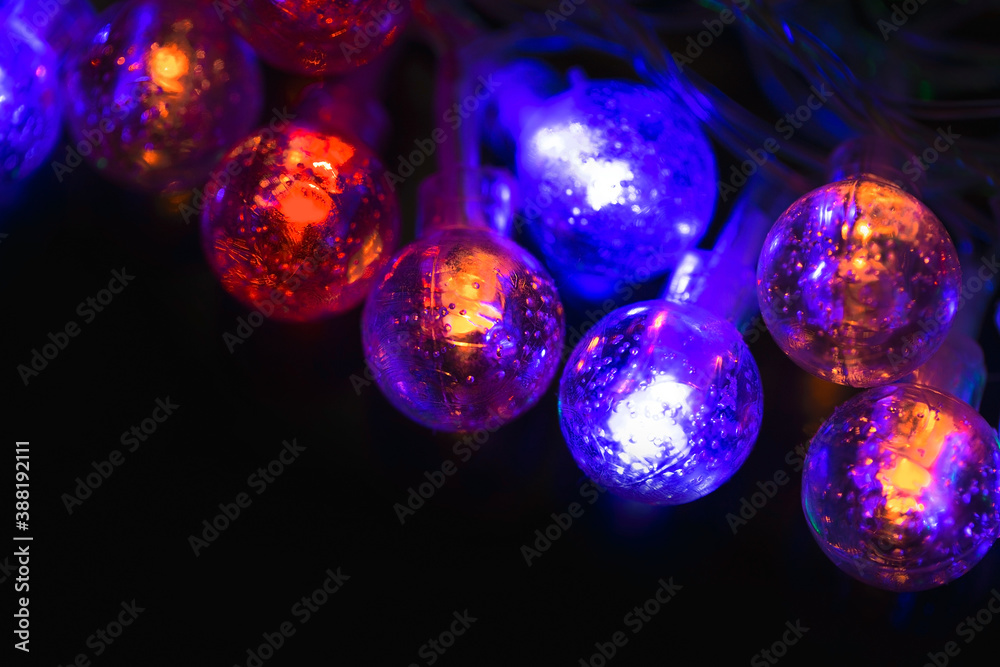 Beautiful Christmas garlands with led lights on a black background. Blue and orange holiday lights Beautiful Christmas garlands with led lights on a black background. Blue and orange holiday lights