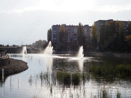 beautiful fountain splashes in the pond of a residential area of the city © Yulia