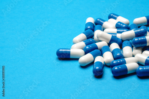 group of pills or capsules on blue background