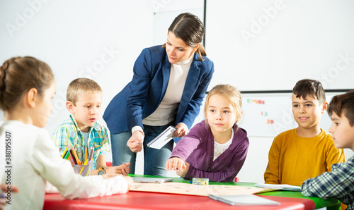 Teacher and pupils play a table game in elementary school class. High quality photo