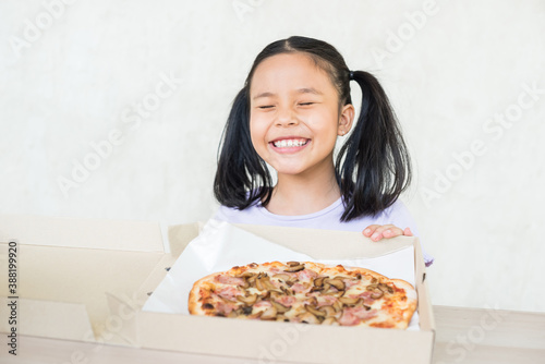 girl recommend eat this delicious pizza   happy hard working food distributor holds opened box with appetizing pizza  delivers in time  courier delivers appetizing fast food in cardboard container.
