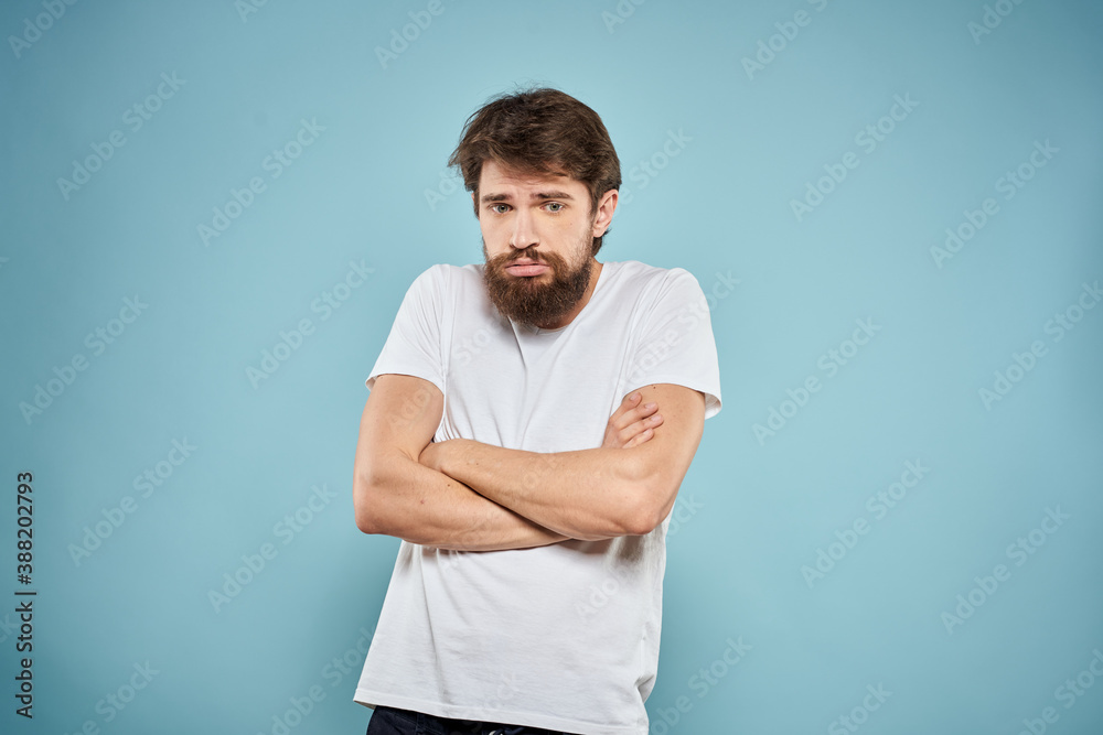 Man in white t-shirt emotions facial expression cropped view studio blue background lifestyle Man in white t-shirt emotions facial expression cropped view studio blue background lifestyle