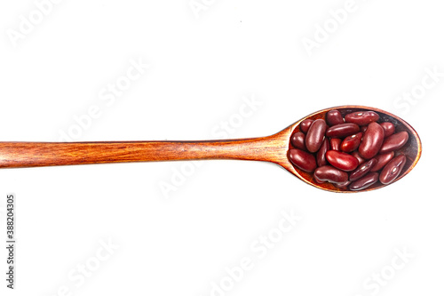 Red kidney beans on wooden spoon isolated on white background.