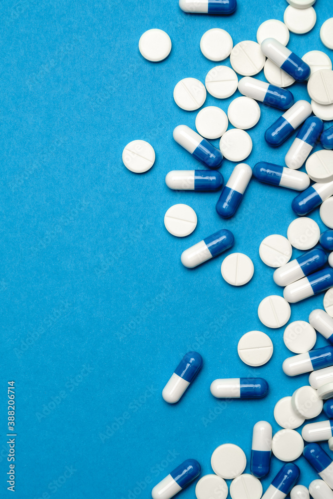 group of pills or capsules on blue background group of pills or capsules on blue background