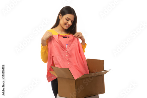 Young woman trying on a top she bought online  © IndiaPix