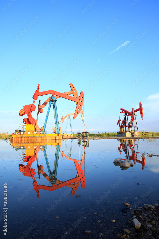 Oil pump under the blue sky, beam pumping unit in the oil field Oil pump under the blue sky, beam pumping unit in the oil field