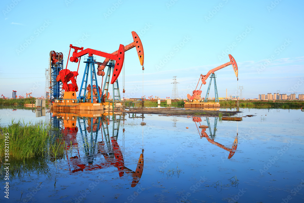Oil pump under the blue sky, beam pumping unit in the oil field Oil pump under the blue sky, beam pumping unit in the oil field