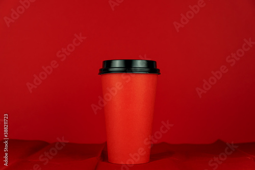 Red Cup of take-out coffee on a red background. © IKvyatkovskaya