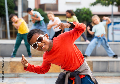 Portrait of preteen boy performing hip hop at outdoors group dance class