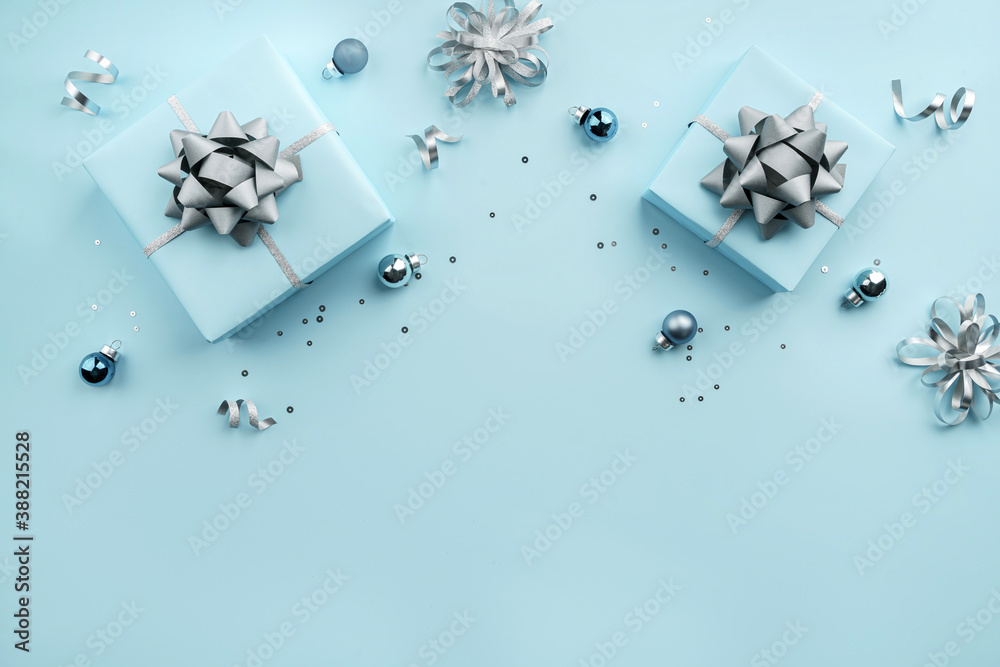 Christmas gift boxes with silver ribbons, decoration, bows, sparkles and confetti on bluebackground. Xmas and New Year greeting card, winter holiday. Flat lay, top view, frame Christmas gift boxes with silver ribbons, decoration, bows, sparkles and confetti on bluebackground. Xmas and New Year greeting card, winter holiday. Flat lay, top view, frame
