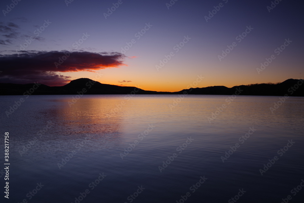 夜明けの屈斜路湖。湖面に映る美しい朝の空。