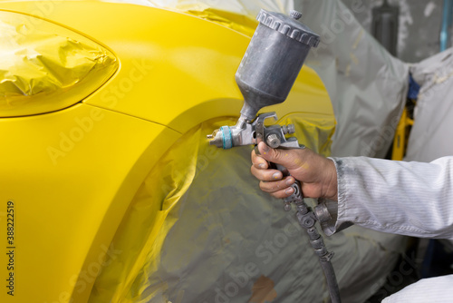 Auto body repair series: Yellow sports car being repaint