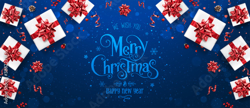 Blue Christmas and New Year text on blue holiday background with gift boxes, red ribbons, decoration, sparkles, confetti, bokeh. Merry Christmas card. Vector Illustration, Xmas theme
