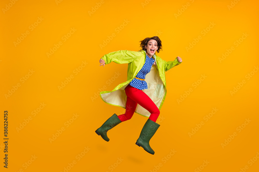 Full length photo portrait of excited girl with open mouth running jumping up isolated on bright yellow colored background