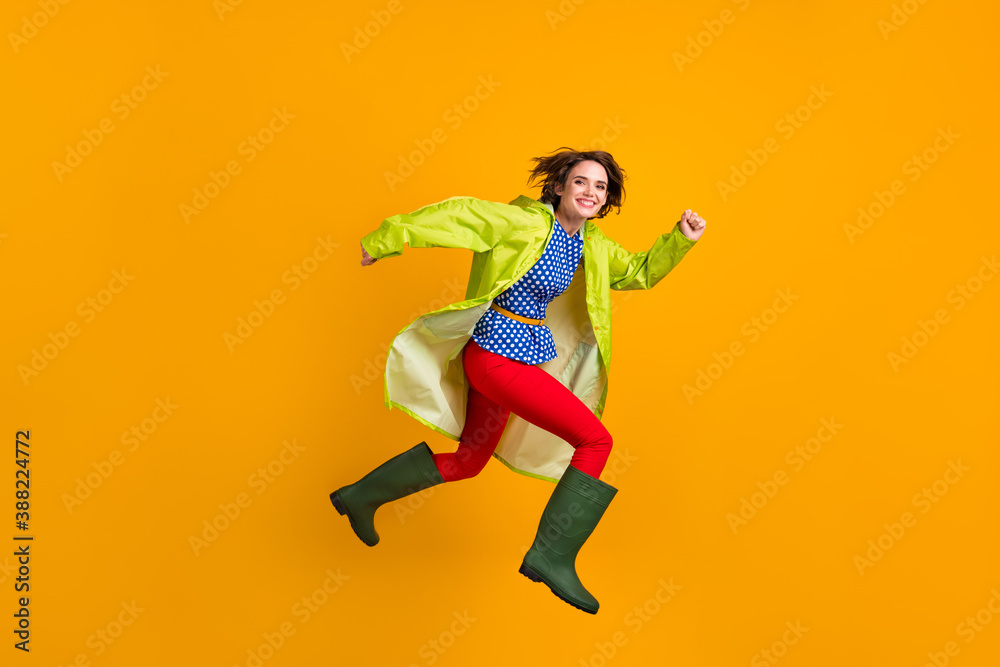 Full length photo portrait of happy girl running jumping up isolated on vivid yellow colored background Full length photo portrait of happy girl running jumping up isolated on vivid yellow colored background