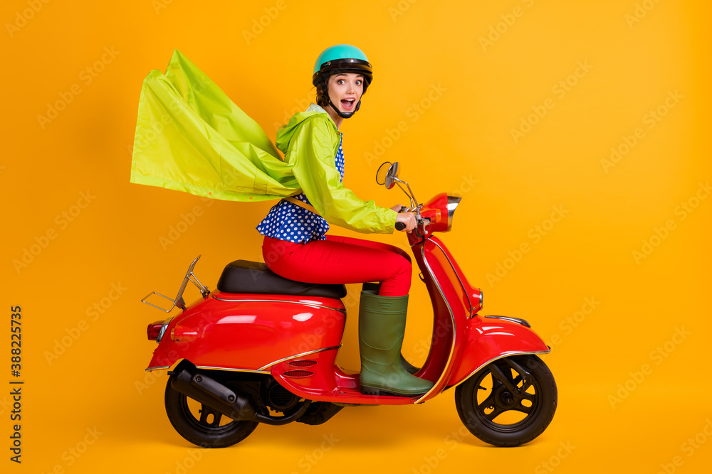 Full length photo portrait of excited girl riding bike isolated on bright yellow colored background