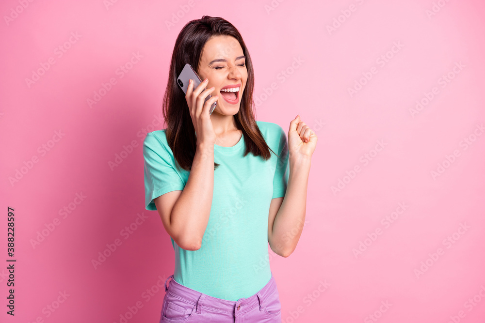 Photo portrait of excited girl celebrating talking over phone isolated on pastel pink colored background Photo portrait of excited girl celebrating talking over phone isolated on pastel pink colored background