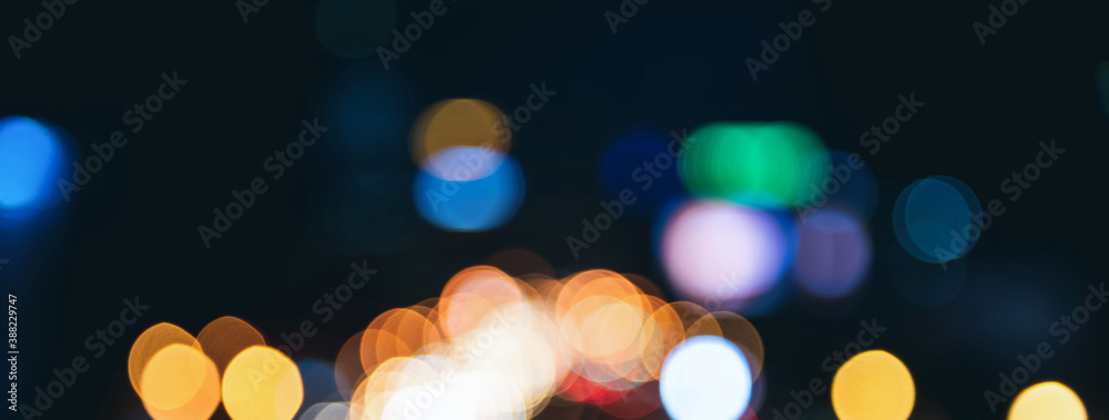 Fototapeta premium Blurred colorful bokeh light at night on dark banner background