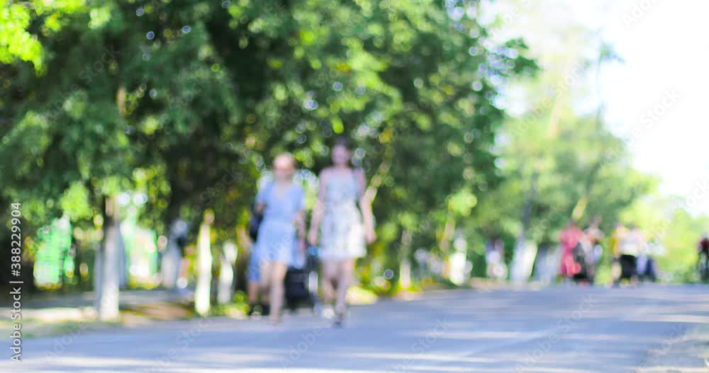 Blurred background of a central park with people walking sunny summer day Blurred background of a central park with people walking sunny summer day