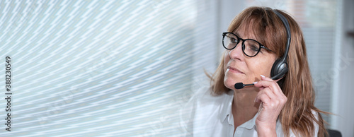 Female helpline operator in headset; panoramic banner