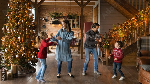 Wide banner panoramic view of happy young Caucasian family with two small kids have fun celebrating Christmas at home. Overjoyed parents with children enjoy New Year winter holidays together. © fizkes