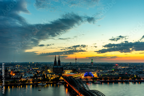 Germany, Cologne, a sunset over a body of water with a city in the background