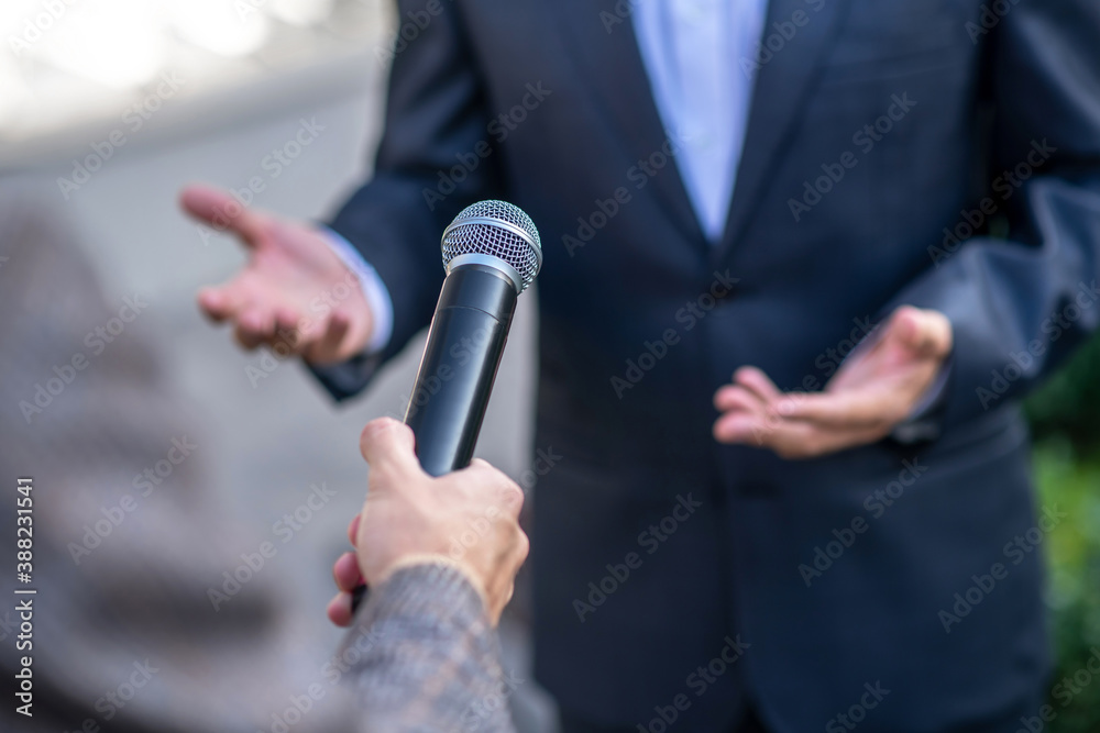Close-up of male hands holding microphone during interview Close-up of male hands holding microphone during interview