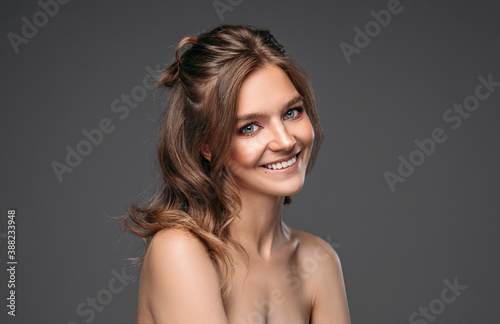 Portrait of cheerful young model isolated on gray backgroud